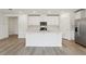 Bright kitchen with white cabinets, stainless steel appliances, center island, and modern fixtures creates a clean, stylish cooking space at 4543 Sidesaddle Trl, St Cloud, FL 34772