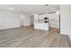 Bright, open-concept living space with modern flooring flowing into a kitchen area with white cabinets and a center island at 4543 Sidesaddle Trl, St Cloud, FL 34772