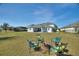 Spacious backyard featuring a fire pit with cozy seating, a lush green lawn, and view of a pool and covered patio at 4608 Egg Harbor Dr, Kissimmee, FL 34746