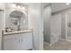 Bright bathroom with granite vanity, round mirror, and a white tiled shower and tub at 4608 Egg Harbor Dr, Kissimmee, FL 34746