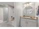 Bright bathroom with granite vanity, round mirror, and a white tiled shower and tub at 4608 Egg Harbor Dr, Kissimmee, FL 34746