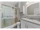 Modern bathroom featuring granite countertops, a glass-enclosed shower with pebble accents, and stylish vanity storage at 4608 Egg Harbor Dr, Kissimmee, FL 34746