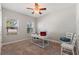 Bright, carpeted bedroom featuring neutral walls, a ceiling fan, and a stylish work-from-home setup bathed in natural light at 4608 Egg Harbor Dr, Kissimmee, FL 34746