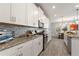 Modern kitchen features granite countertops, stainless steel appliances, gray tile backsplash and hardwood floors at 4608 Egg Harbor Dr, Kissimmee, FL 34746
