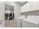 Functional laundry room with white appliances, built-in cabinets, and access to a spacious walk-in closet at 4608 Egg Harbor Dr, Kissimmee, FL 34746