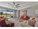 Inviting living room with plush seating, decorative rug, large windows overlooking backyard, and a ceiling fan at 4608 Egg Harbor Dr, Kissimmee, FL 34746
