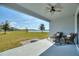 Inviting outdoor patio with comfortable seating, a ceiling fan, and a scenic view of the lush lawn and lake at 4608 Egg Harbor Dr, Kissimmee, FL 34746