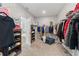 Large walk-in closet with custom shelving, organized clothing, and an adjacent en-suite bathroom at 4608 Egg Harbor Dr, Kissimmee, FL 34746