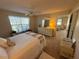 Cozy bedroom with a large window, ceiling fan, a dresser with mirror, and carpet flooring at 482 Hildalgo Dr, The Villages, FL 32159