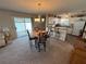Open concept dining area with a chandelier, table for four, and sliding door to the patio at 482 Hildalgo Dr, The Villages, FL 32159