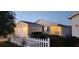 House exterior at dusk with white picket fence at 482 Hildalgo Dr, The Villages, FL 32159