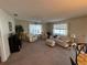 Comfortable living room featuring large windows, neutral tones, and a ceiling fan at 482 Hildalgo Dr, The Villages, FL 32159