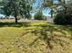The backyard of this property features ample green space with mature trees and a partial fence line at 525 Aster Dr, Davenport, FL 33897