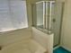 Bright bathroom featuring a bathtub, a shower, tiled walls, and a large window at 525 Aster Dr, Davenport, FL 33897