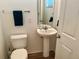 Small bathroom with pedestal sink, toilet, mirror and towel rack, offering essential amenities at 525 Aster Dr, Davenport, FL 33897