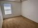 Bright empty room with neutral carpet and a window, ready for personalization and decor at 525 Aster Dr, Davenport, FL 33897