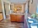 Kitchen featuring wood cabinets, wood-look flooring, an island, and stainless steel sink at 525 Aster Dr, Davenport, FL 33897