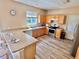 Well-equipped kitchen with stainless steel appliances, breakfast bar, and modern laminate flooring at 525 Aster Dr, Davenport, FL 33897