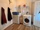 Well-lit laundry room with washer, dryer, storage shelf, and a door for convenient access at 525 Aster Dr, Davenport, FL 33897