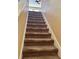 Carpeted staircase leading to the upper level of the home; ceiling fan above at 525 Aster Dr, Davenport, FL 33897