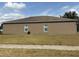 Stucco home exterior featuring two windows, neutral color, and well maintained lawn at 5610 Forest Ridge Dr, Winter Haven, FL 33881