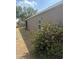 A view of the side of the home, showcasing the backyard area with lush green shrubs at 5610 Forest Ridge Dr, Winter Haven, FL 33881