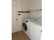 Practical laundry room with full-size washer and dryer and storage shelving at 5610 Forest Ridge Dr, Winter Haven, FL 33881