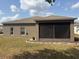 Rear exterior showcasing neutral stucco and a screened in porch at 5610 Forest Ridge Dr, Winter Haven, FL 33881