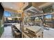 Outdoor kitchen with stainless steel appliances and seating area overlooking a pool and golf course at 6001 Caymus Loop, Windermere, FL 34786