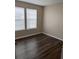 Bedroom with wood floors and natural light from two windows at 6088 Westgate Dr # 103, Orlando, FL 32835