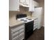 White kitchen with black appliances and granite countertops at 6088 Westgate Dr # 103, Orlando, FL 32835
