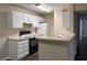 Functional kitchen featuring white cabinetry, black appliances, and a breakfast bar at 6088 Westgate Dr # 103, Orlando, FL 32835