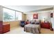 Comfortable bedroom with an oversized window, a single person seat, and dark-stained wooden furniture at 690 Osceola Ave # 604, Winter Park, FL 32789