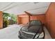 Covered carport area with a sleek black car parked inside, offering protection from the elements at 690 Osceola Ave # 604, Winter Park, FL 32789