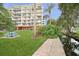 Beautiful exterior view of the condo building with lush landscaping, a stream and a blue picnic table at 690 Osceola Ave # 604, Winter Park, FL 32789