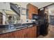 A stylish kitchen offers rich cabinetry, granite countertops, and stainless appliances, connecting to a comfortable living space at 690 Osceola Ave # 604, Winter Park, FL 32789