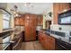 Modern kitchen featuring dark granite countertops, stainless steel appliances, and ample wood cabinet storage at 690 Osceola Ave # 604, Winter Park, FL 32789