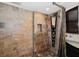 Modern shower with stone-tiled walls and floor, a built-in shelf, and upgraded shower fixture at 690 Osceola Ave # 604, Winter Park, FL 32789