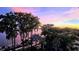 A stunning waterfront view with lush trees and colorful sunset in the background at 690 Osceola Ave # 604, Winter Park, FL 32789