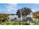 Stunning waterfront view with a private dock, surrounded by lush greenery and mature trees under a beautiful blue sky at 690 Osceola Ave # 604, Winter Park, FL 32789