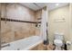 Bathroom with shower/tub combo, tile surround, and a toilet at 718 32Nd St, Orlando, FL 32806