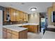 Galley-style kitchen with light wood cabinets and mosaic backsplash at 718 32Nd St, Orlando, FL 32806