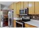 Modern kitchen with wood cabinets, stainless steel appliances, and tile backsplash at 718 32Nd St, Orlando, FL 32806