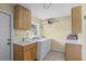 Laundry room with washer, dryer, cabinets, and utility sink at 718 32Nd St, Orlando, FL 32806