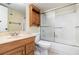 Bathroom with a bathtub and shower combination, white tiled walls and traditional oak vanity at 7340 Daniel Webster Dr # 7, Winter Park, FL 32792