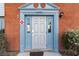 Inviting townhouse front door with brick exterior and attractive blue accents at 7340 Daniel Webster Dr # 7, Winter Park, FL 32792