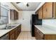 Functional kitchen with tiled floor, wood cabinets and double stainless steel sink at 7340 Daniel Webster Dr # 7, Winter Park, FL 32792