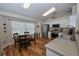 Bright breakfast nook with a large window, round table, and white cabinetry in the adjacent kitchen at 1001 Willow Run St., Minneola, FL 34715