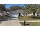 Beautiful one-story home with mature trees, a manicured lawn, and a two-car garage at 1001 Willow Run St., Minneola, FL 34715