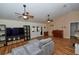 A spacious living room featuring hardwood floors, ceiling fans, and plenty of natural light at 1001 Willow Run St., Minneola, FL 34715